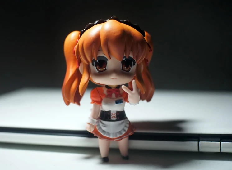 a close up of a doll in front of a laptop, inspired by Fujiwara Takanobu, pixiv, style as nendoroid, orange and white, ( waitress ) girl, wide angle photo