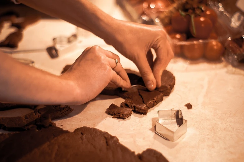 a close up of a person making a cookie, by Jakob Gauermann, process art, clay amulets, chocolate, catalog photo, artistic composition