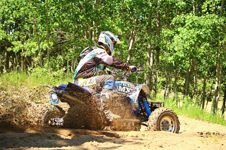 a man riding on the back of a dirt bike, a portrait, flickr, blue indygo thunder lightning, all terrain vehicle race, slick!!, grand finale