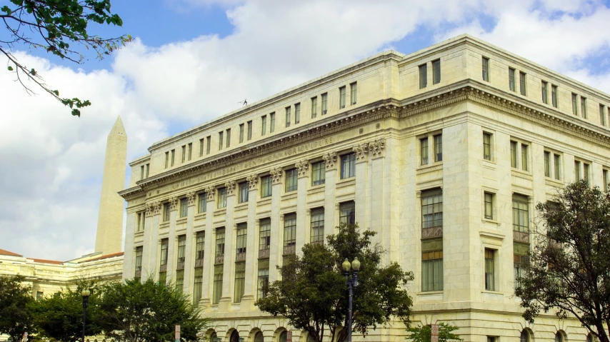 a large white building with a clock tower in the background, by Luis Miranda, us court, banner, dc, front elevation