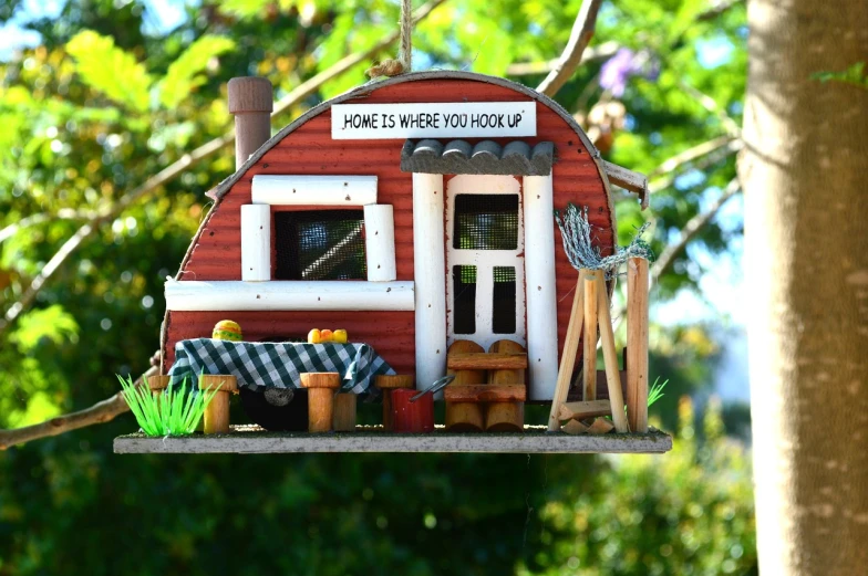 a close up of a birdhouse on a tree, inspired by Jacek Yerka, flickr, with a roof rack, caravan, photo of a model, detailed image