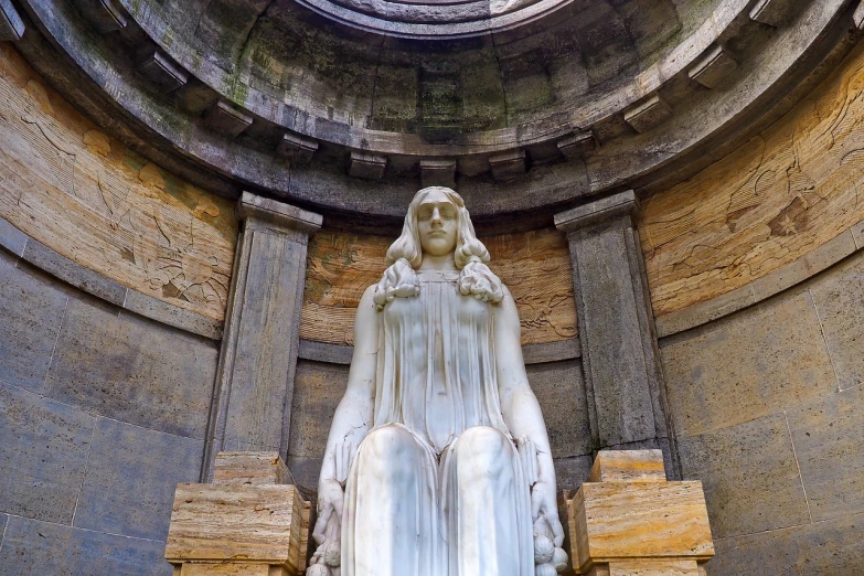 a statue of a woman sitting on a bench, by Luis Miranda, shutterstock, neoclassicism, stone grotto in the center, style of jean delville, symmetrical front view, viewed from below