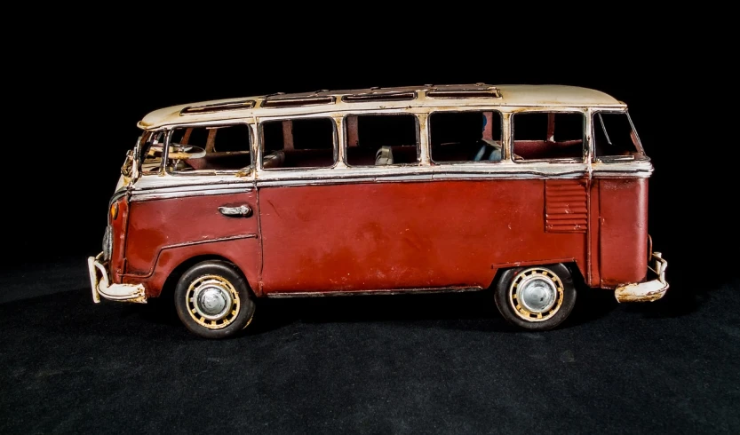 a red and white bus sitting on top of a black surface, by Richard Carline, stained antique copper car paint, detailed clay model, kombi, full face view