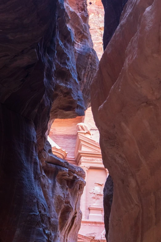 a person riding a horse through a narrow canyon, inspired by Antonín Chittussi, unsplash contest winner, art nouveau, red sandstone natural sculptures, sculptured face, arabia, adorned pillars