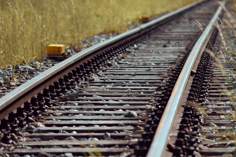 a close up of a train track near a field, shutterstock, detailed depth of field, high quality image”, hyperrealistic ”, stock photo