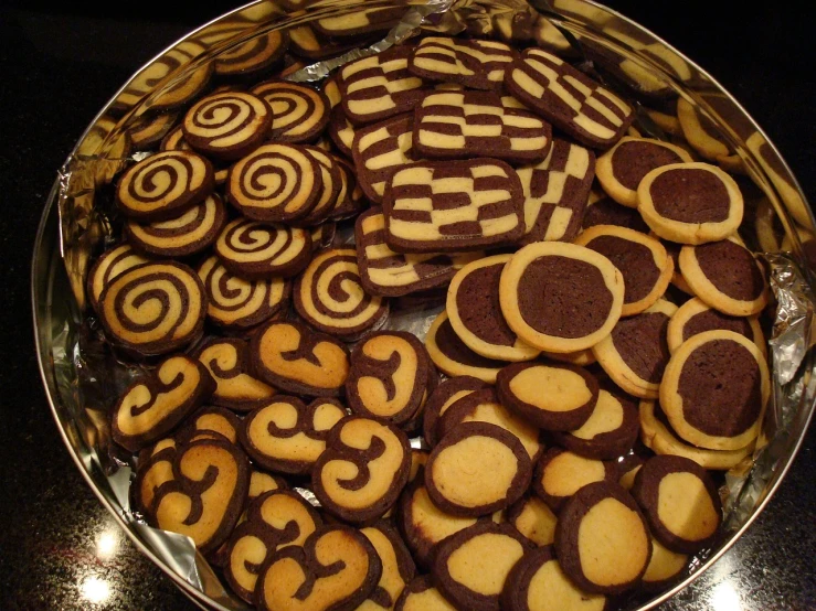 a pan filled with lots of cookies on top of a table, flickr, op art, spiraling design, cakes, intarsia, :3