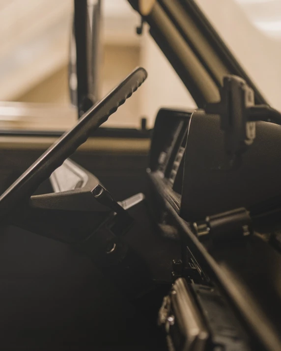 a cell phone sitting in the driver's seat of a car, by Karl Buesgen, unsplash, modernism, countach, levers, side view close up of a gaunt, faded and dusty