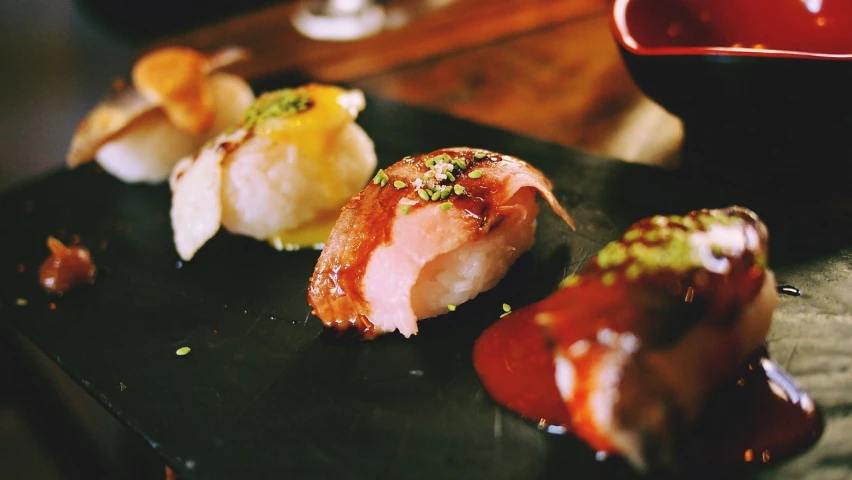 a close up of a plate of food on a table, a picture, inspired by Kanō Shōsenin, unsplash, glazed, sushi, molten, low quality grainy