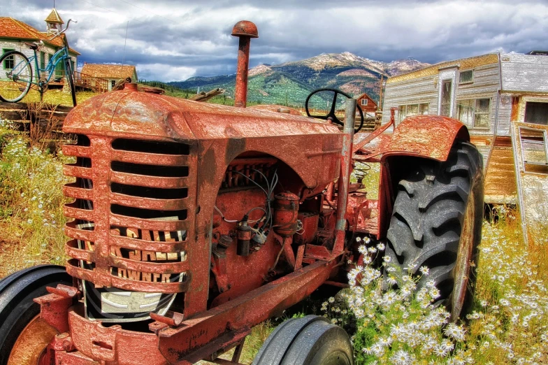 an old red tractor sitting in a field, a colorized photo, by Arnie Swekel, shutterstock contest winner, intricate details and textures, colorado, flower power, rusty helmet