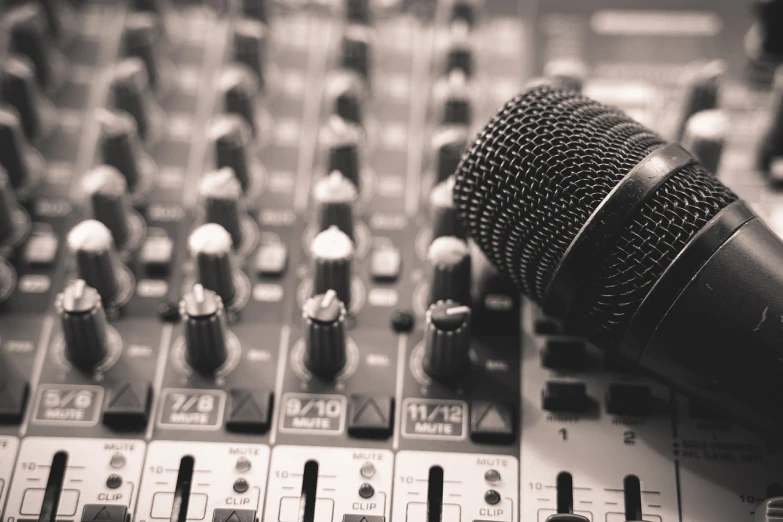 a microphone sitting on top of a sound board, a picture, by Joe Sorren, shutterstock, sepia tone, dj mixer, shot on sony a 7, powerful detail