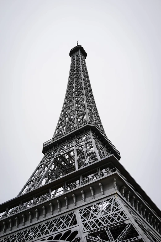 a black and white photo of the eiffel tower, a picture, paris school, low shot angle, nice slight overcast weather, tourist destination, grey metal body