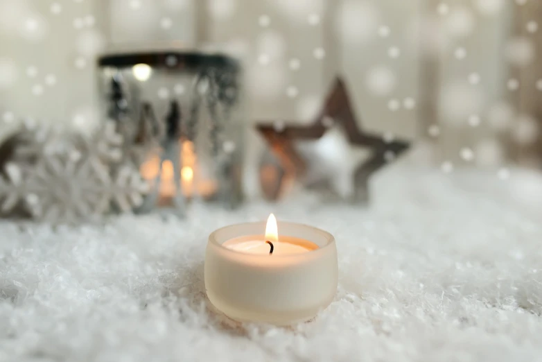 a lit candle sitting on top of a snow covered ground, a picture, miniature product photo, white stars in the background, smooth white surroundings, decoration around the room