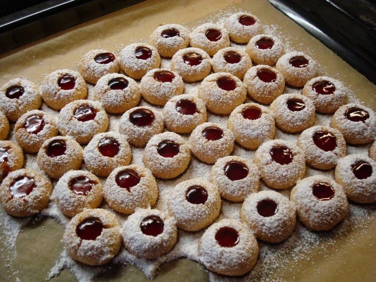 a table topped with lots of cookies covered in powdered sugar, flickr, hurufiyya, raspberry, thumbprint, mandel eyes, ffffound