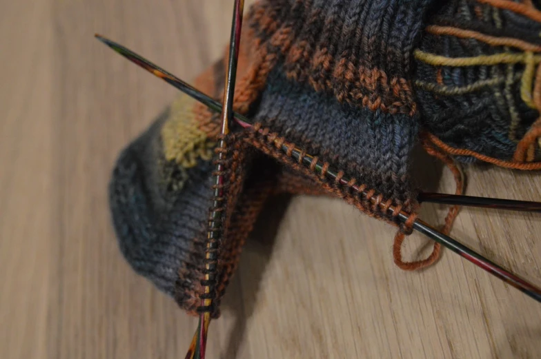 a close up of a pair of knitting needles, by Maksimilijan Vanka, process art, socks, autumnal, dragon paws, double layer fold over hem