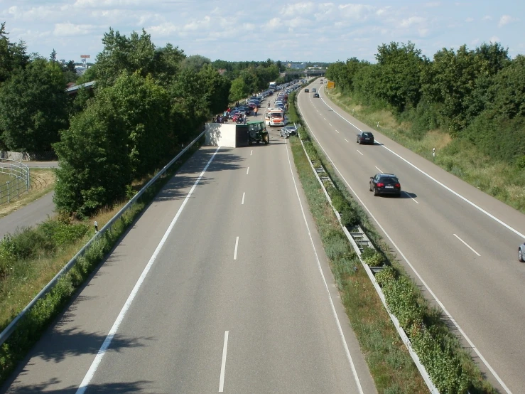 a highway filled with lots of traffic next to a forest, by Werner Gutzeit, flickr, figuration libre, wikimedia commons, france, plain view, highly technical