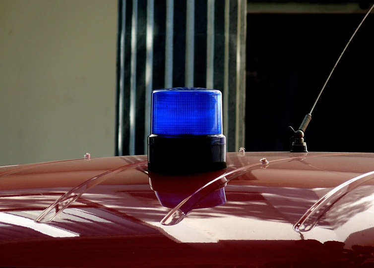 a blue light sitting on top of a red car, by Christen Dalsgaard, flickr, police calling for back up, [ [ hyperrealistic ] ], light cone, new mexico