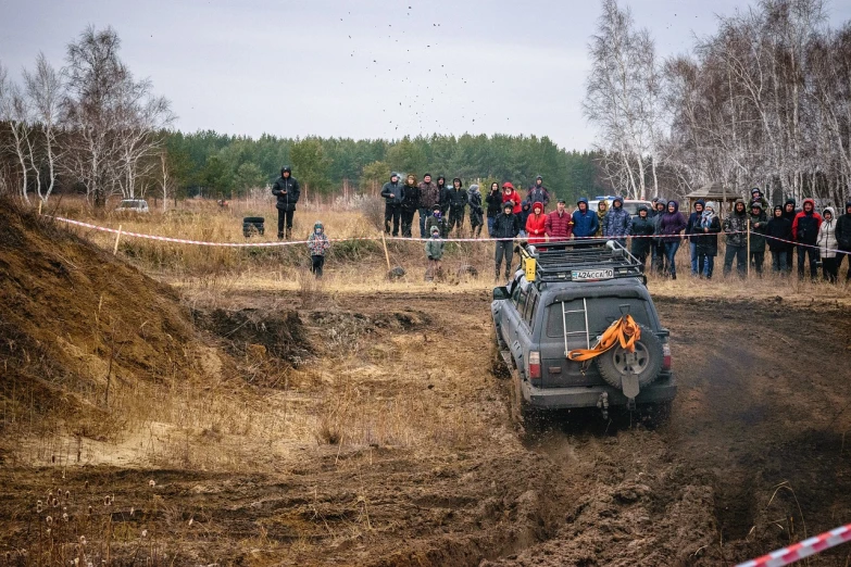 a jeep driving down a dirt road in front of a group of people, shutterstock, realism, russian lada car, in a race competition, high quality photos, blog-photo