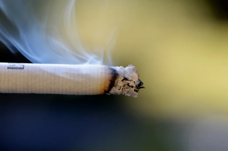 a cigarette with smoke coming out of it, shutterstock, photograph credit: ap, hoog detail, low dof, warm weather