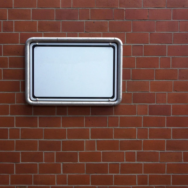 a white sign mounted to the side of a brick wall, a photo, postminimalism, metal lid, whiteboard, symmetrically, outdoor photo