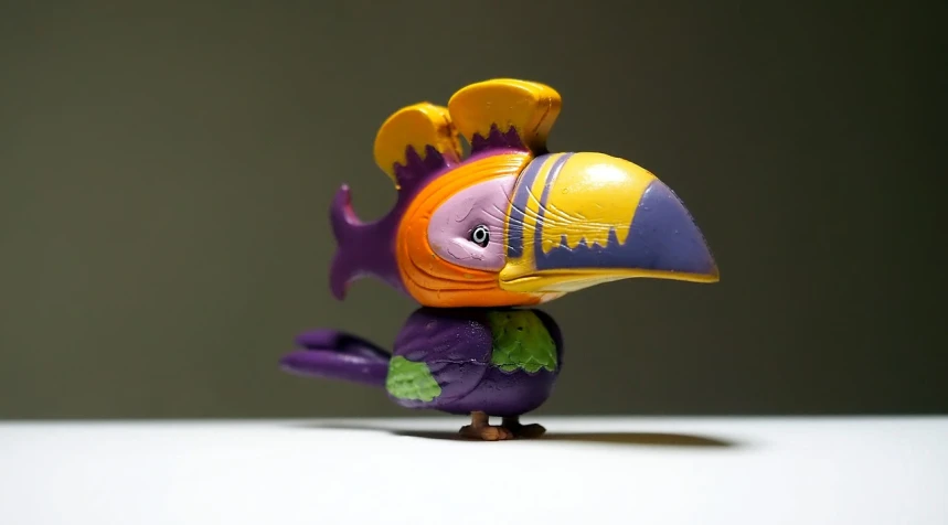 a close up of a toy bird on a table, inspired by Charles Bird King, trending on polycount, toyism, purple head, tropical birds, pirate, side - view