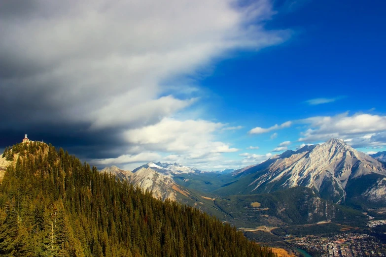 a couple of people standing on top of a mountain, a tilt shift photo, inspired by James Pittendrigh MacGillivray, yeg, harmony of swirly clouds, looking down at the valley, denis velleneuve