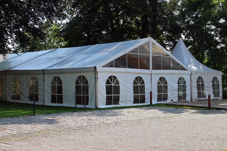 a large white tent sitting on top of a lush green field, pixabay, art nouveau, clear glass wall, wedding, exterior photo, covered outdoor stage