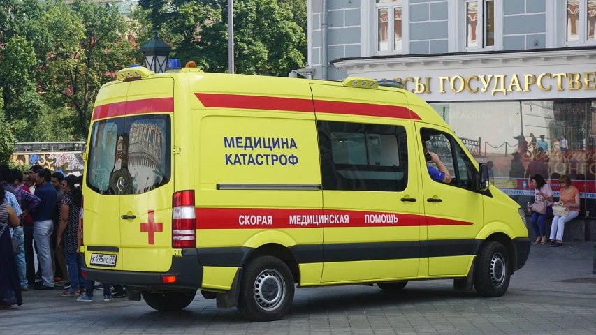 a yellow ambulance parked in front of a group of people, by Maksimilijan Vanka, sanctions in russia, full-body-shot, medical labels, mercedes