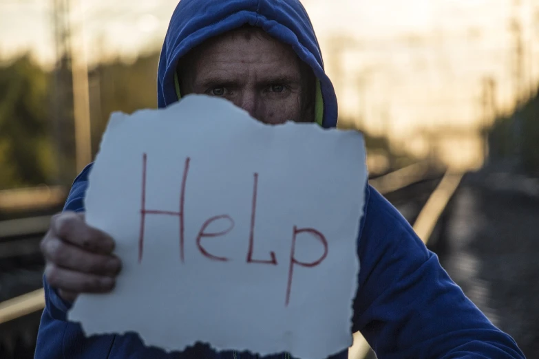 a man holding a sign that says help, by Jan Konůpek, skilled homeless, camp, # oc, aleksander rostov