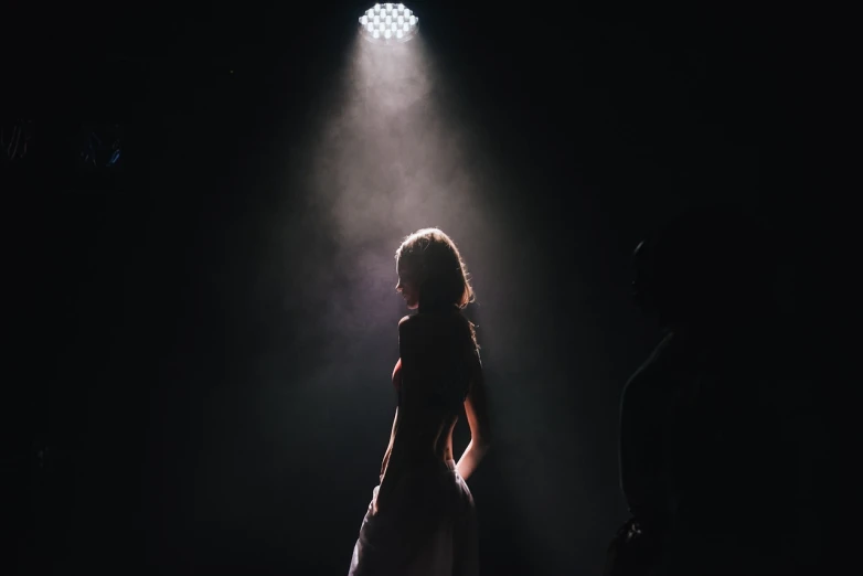 a woman that is standing in the dark, pexels contest winner, light and space, stage light, on the runway, beautiful lighting uhd, sensual dancing