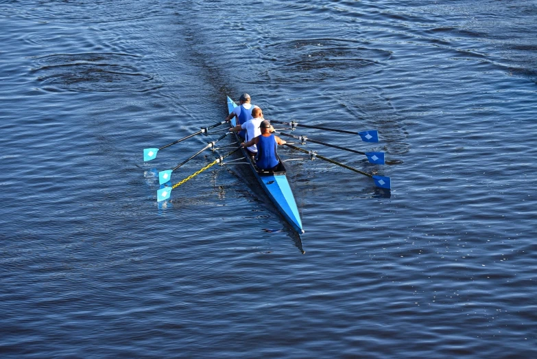 a couple of people riding on top of a boat, by Grytė Pintukaitė, flickr, hurufiyya, blue colour scheme, sport, in a row, 3 boat in river