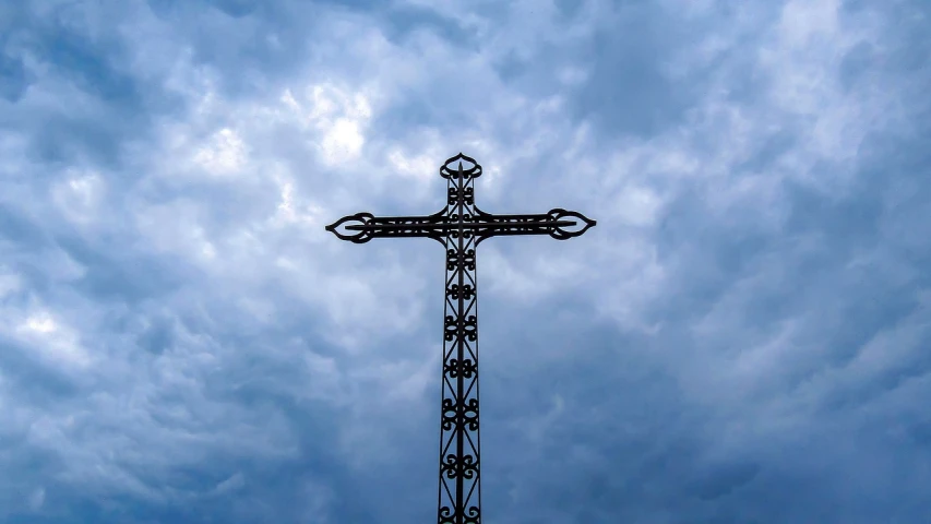 a cross is silhouetted against a cloudy sky, by Jan Rustem, unsplash, hurufiyya, metalwork, traditional corsican, a 15 foot tall, july 2 0 1 1