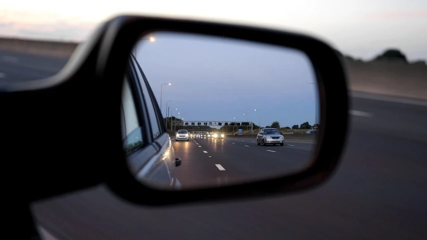 a rear view mirror on the side of a car, by Cornelisz Hendriksz Vroom, accurate roads, lights in distance, mirrors, slight overcast