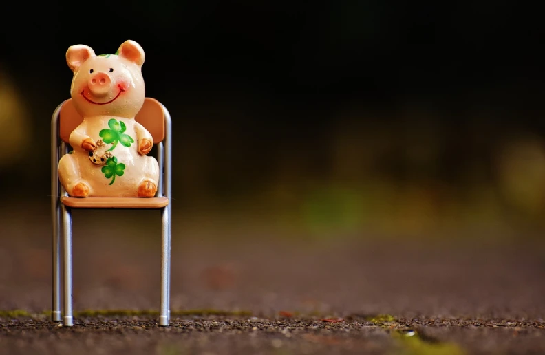 a figurine of a pig sitting on a chair, a picture, by Adam Marczyński, trending on pixabay, clover, roadside, wooden banks, animation still