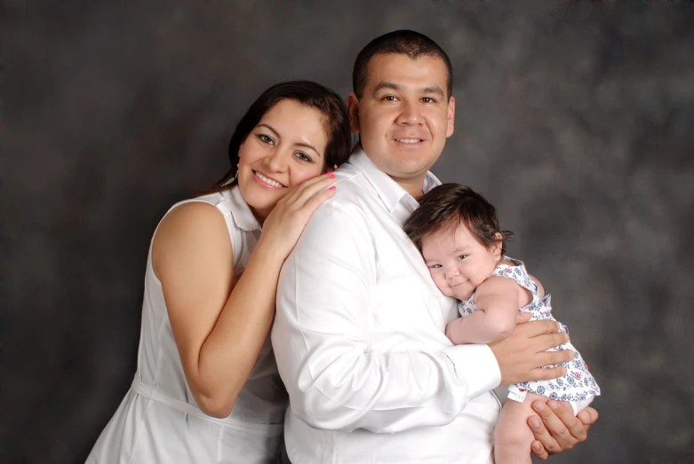 a man and a woman holding a baby, a portrait, by Randy Vargas, flickr, wearing white cloths, studio!! portrait lighting, square, latinas