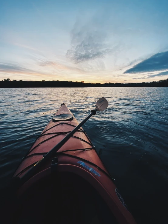 a red kayak sitting on top of a body of water, a picture, by Matt Cavotta, unsplash, going forward to the sunset, first-person pov, slight overcast, campy