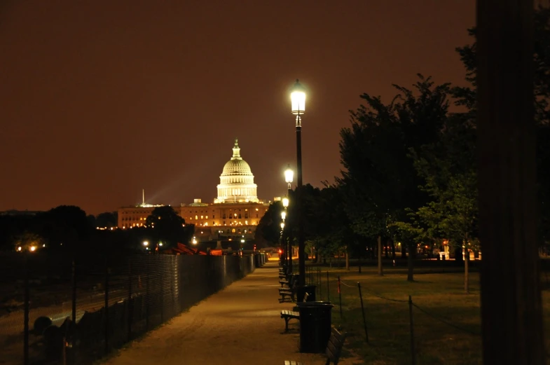 a view of the capitol building at night, a picture, by Tom Carapic, flickr, plein air, walking to the right, long distance photo, city park, sandy