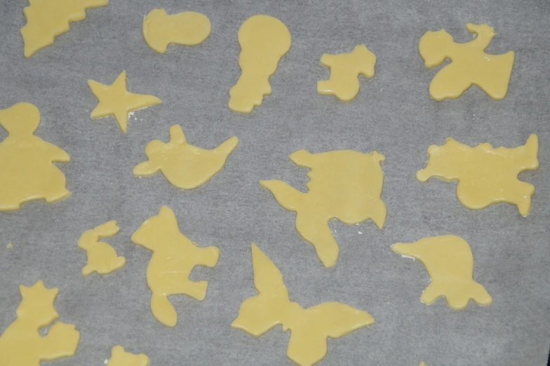 a close up of a tray of cookies on a table, a silk screen, inspired by Jean Arp, reddit, melting into vulpix, random positions floating, cut out, melted cheese