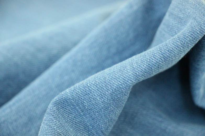 a close up of a piece of blue fabric, unsplash, wearing a light blue shirt, cozy calm! fabrics textiles, banner, taken with a canon eos 5d