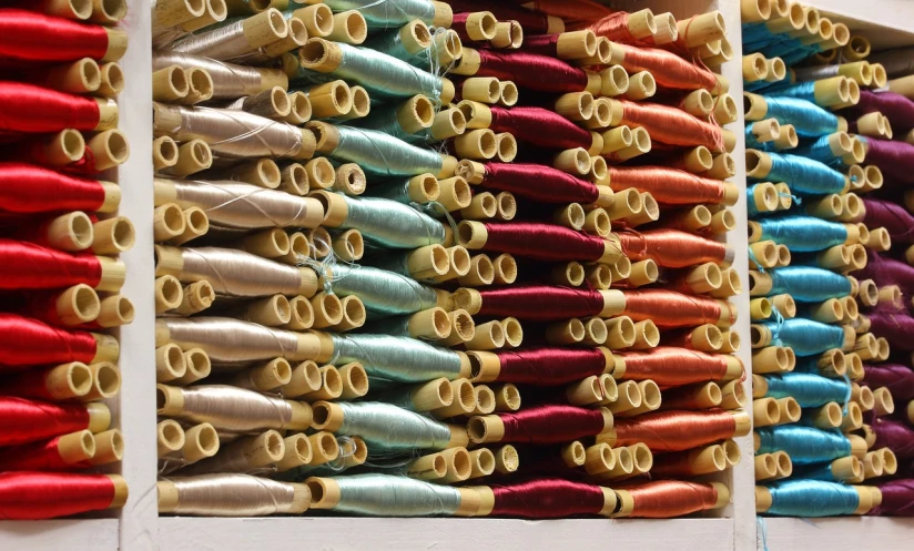 a close up of a bunch of spools of thread, a cross stitch, by David Simpson, flickr, process art, flowing silk sheets, reeds, o'neill cylinder colony, vintage inspired