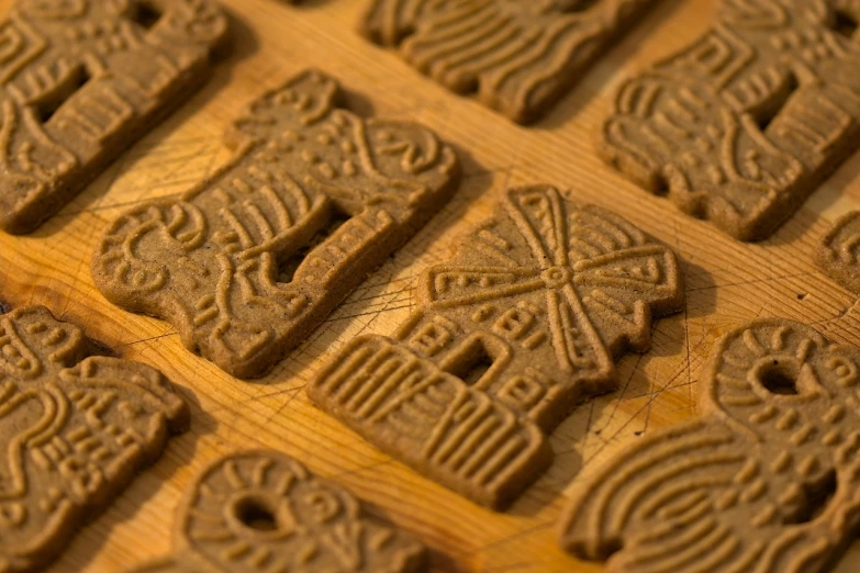 a bunch of cookies sitting on top of a wooden table, by Aleksander Gierymski, flickr, folk art, windmills, embossed, closeup - view, hieroglyphics