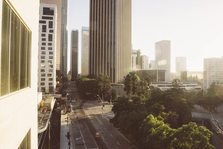 a city street filled with lots of tall buildings, a matte painting, unsplash contest winner, realism, southern california, summer morning light, 1128x191 resolution, shot with hasselblad