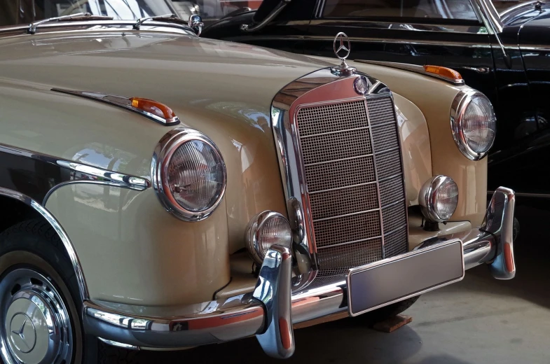 a couple of old cars parked next to each other, arabesque, indoor, german, medium closeup, mercedez benz