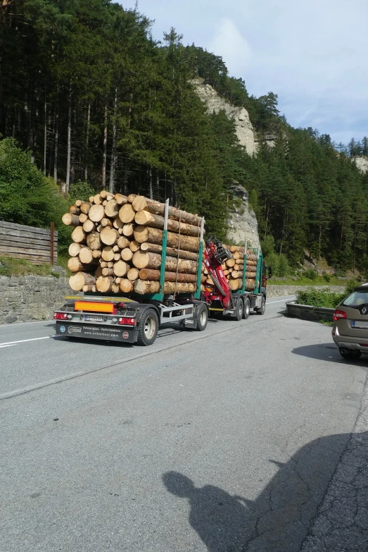 a truck loaded with logs on the side of the road, a photo, by Erwin Bowien, shutterstock, iphone capture, menacing!!!, switzerland, in avila pinewood