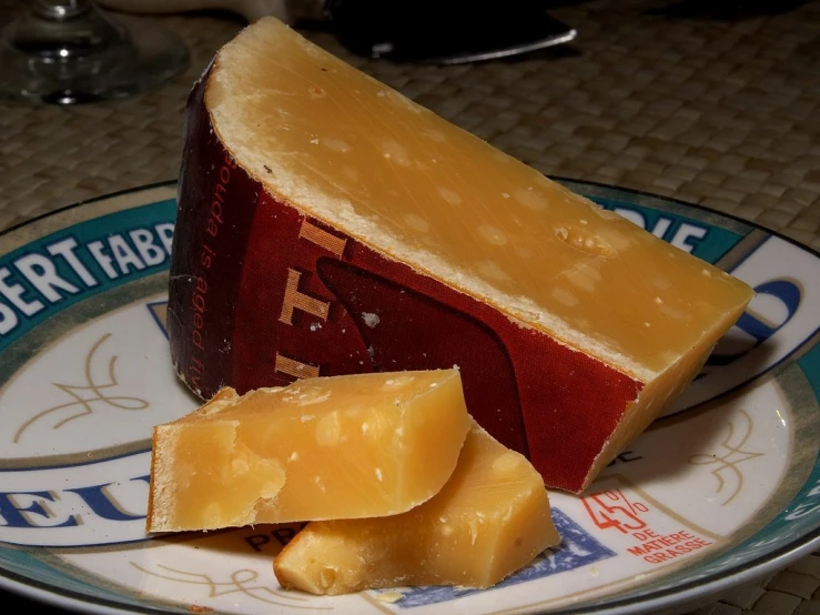 a piece of cheese sitting on top of a plate, by Hans von Bartels, slightly red, rum, long snout, ohio