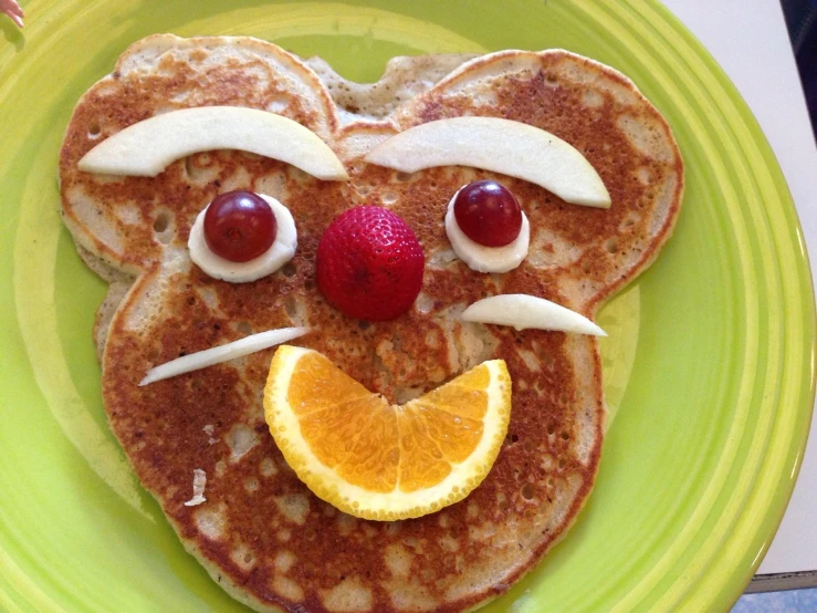 a green plate topped with pancakes covered in fruit, inspired by Stan and Jan Berenstain, flickr, mouse face, strong pixar wheat bread warrior, closeup!!, tony the tiger