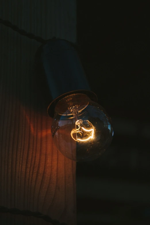 a close up of a light bulb on a wooden wall, unsplash, realism, night outside, shot on kodak vision 200t, holding electricity, emitting light ornaments