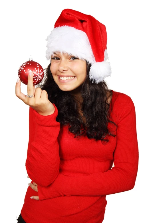 a woman in a santa hat holding a christmas ornament, a photo, latina, istockphoto, teenager girl, fun pose