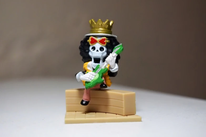a figurine of a skeleton playing a guitar, by Hiroyuki Tajima, with a gold crown, harley queen, 8k!!, rubble!!