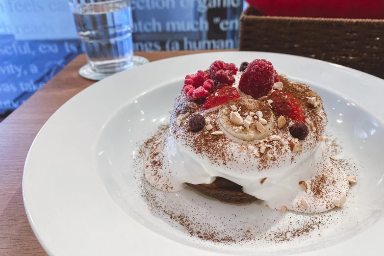 a dessert sitting on top of a white plate, by Emma Andijewska, in a bright cafe, living food adorable pancake, red brown and white color scheme, 🦩🪐🐞👩🏻🦳