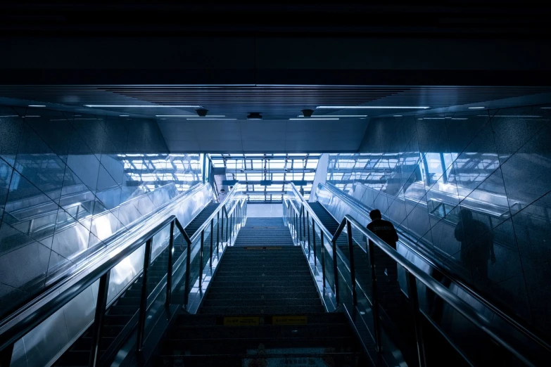 a person standing at the bottom of an escalator, by Tobias Stimmer, unsplash contest winner, dramatic blue light, cyberpunk streets in japan, train station, [ [ hyperrealistic ] ]